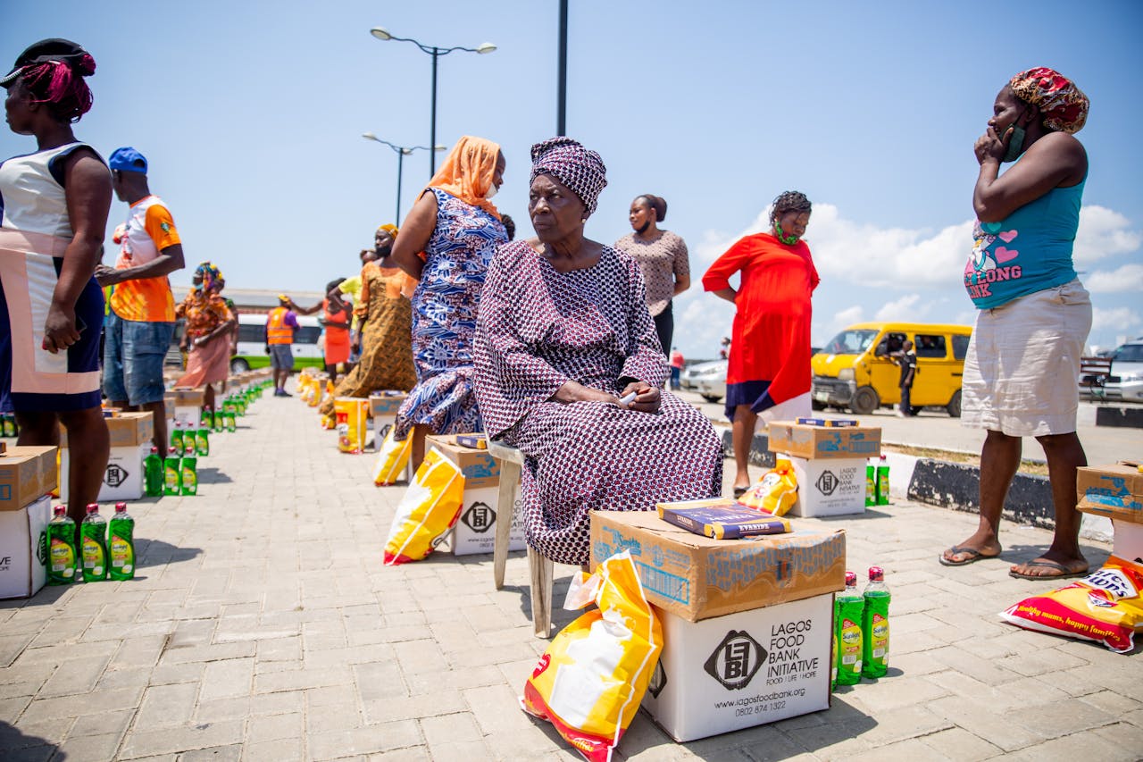 services-04 A group of women receiving aid packages from Lagos Food Bank on a sunny day.